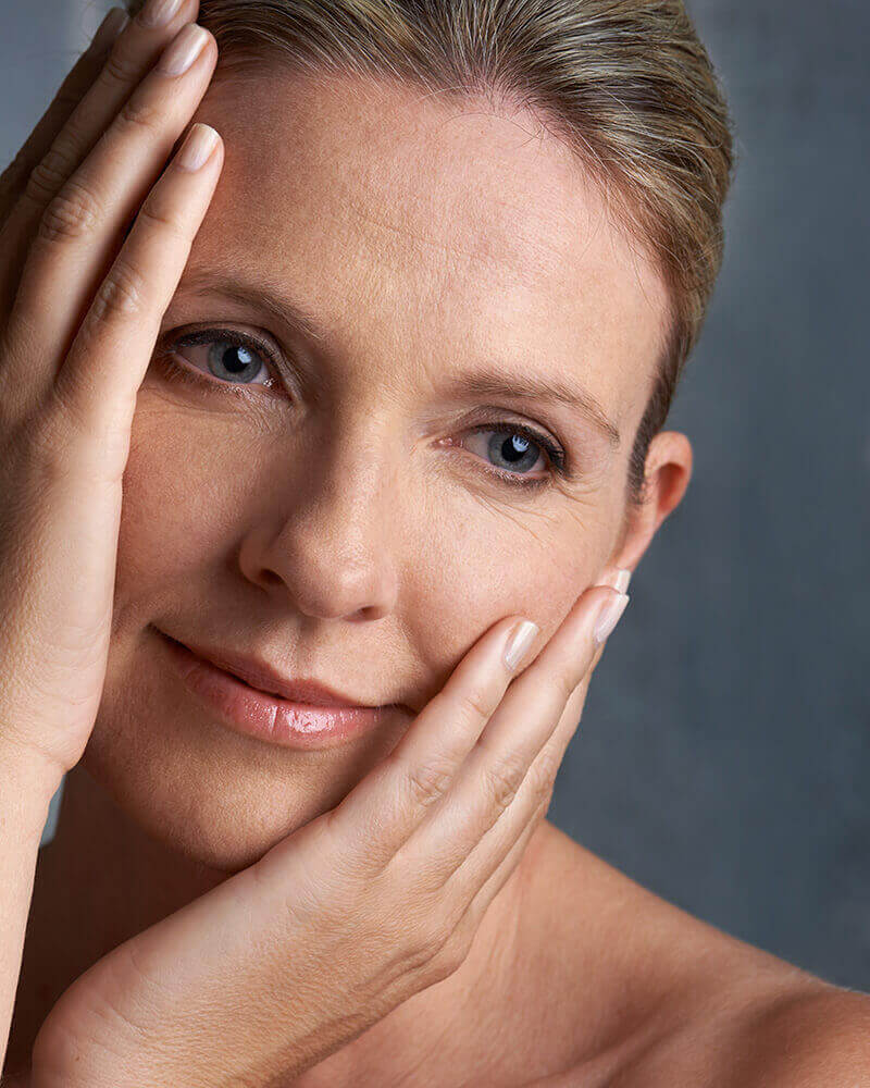 Mature woman touching her face