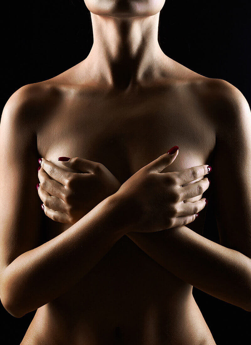 Nude woman covering her breasts