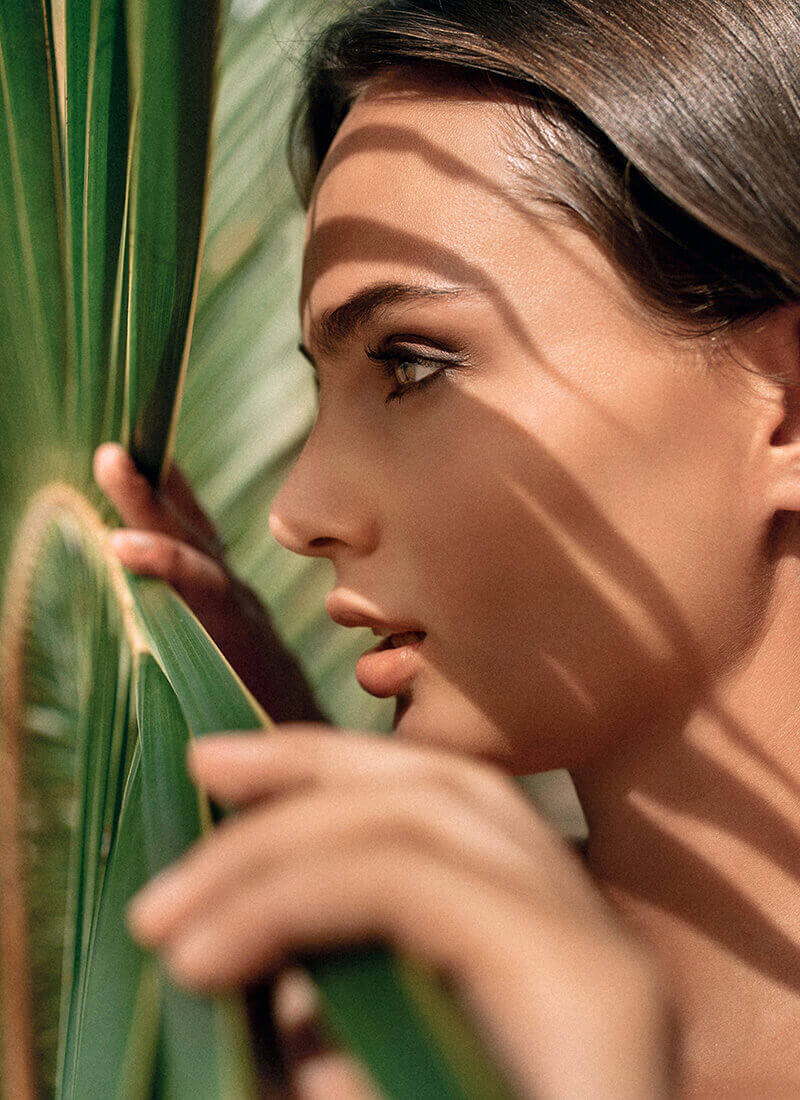 Woman looking over a palm leaf